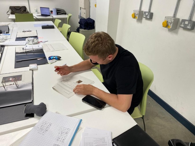 A man sat at a table filling in paperwork.